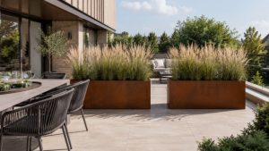 Long corten metal planter terrace planters with tall grasses beside a premium outdoor dining area.